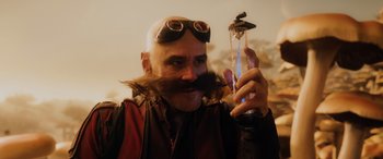 Movie still from “Sonic the Hedgehog” (2020), directed by Jeff Fowler – A man with a beard and a mustache holding a bottle; Medium shot, Over the shoulder angle