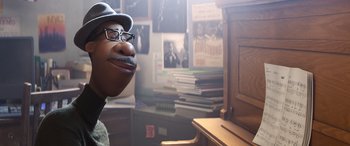 Movie still from “Soul” (2020), directed by Kemp Powers – A man sitting at a piano in front of a bunch of books; Close Up shot, Over the shoulder angle