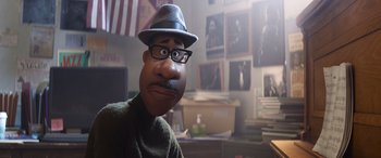 Movie still from “Soul” (2020), directed by Kemp Powers – A man wearing a hat and glasses in a room; Close Up shot, Over the shoulder angle