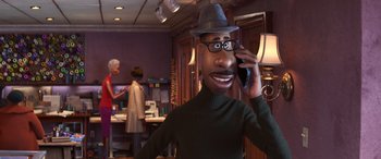 Movie still from “Soul” (2020), directed by Kemp Powers – An animated man talking on a cell phone in a room; Medium shot, Over the shoulder angle