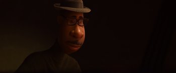 Movie still from “Soul” (2020), directed by Kemp Powers – A man wearing a hat and glasses with his head tilted to the side; Extreme Close Up shot, High angle