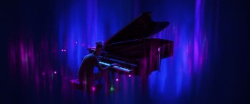 Movie still from “Soul” (2020), directed by Kemp Powers – A man sitting at a grand piano in front of a blue background; Extreme Wide shot, High angle