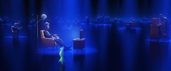 Movie still from “Soul” (2020), directed by Kemp Powers – A person sitting on a couch in a room with blue lighting; Extreme Wide shot, Over the shoulder angle