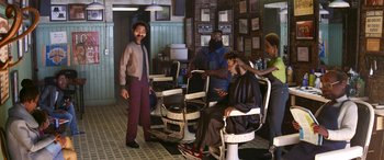 Movie still from “Soul” (2020), directed by Kemp Powers – A man standing in front of a group of people in a barber shop; Wide shot, Low angle
