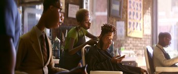 Movie still from “Soul” (2020), directed by Kemp Powers – A woman cutting a man's hair in a barber shop; Medium shot, Over the shoulder angle
