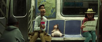 Movie still from “Soul” (2020), directed by Kemp Powers – A man sitting next to a cat on a train; Medium shot, Low angle