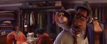 Movie still from “Soul” (2020), directed by Kemp Powers – A man holding a cat on top of a man's shoulder; Close Up shot, Over the shoulder angle