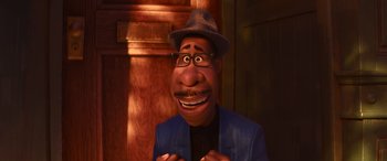 Movie still from “Soul” (2020), directed by Kemp Powers – A man with a hat and glasses is smiling for the camera; Close Up shot, High angle