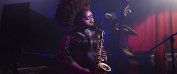Movie still from “Soul” (2020), directed by Kemp Powers – A woman in a black dress playing a saxophone; Medium shot, Low angle
