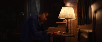 Movie still from “Soul” (2020), directed by Kemp Powers – A man sitting at a table next to a lamp; Medium shot, High angle