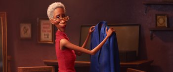 Movie still from “Soul” (2020), directed by Kemp Powers – An animated woman holding a blue shirt in front of a television; Medium shot, Over the shoulder angle