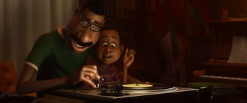 Movie still from “Soul” (2020), directed by Kemp Powers – A man and a boy are sitting at a table with a record player; Medium shot, Low angle