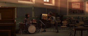 Movie still from “Soul” (2020), directed by Kemp Powers – A man holding up a picture while a woman plays drums; Wide shot, High angle