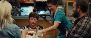 Movie still from “Brightburn” (2019), directed by David Yarovesky – A woman serving a child a piece of cake; Medium shot, Over the shoulder angle