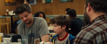 Movie still from “Brightburn” (2019), directed by David Yarovesky – A young boy sitting at a table with a cake; Close Up shot, Over the shoulder angle