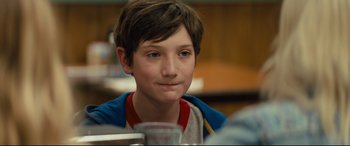 Movie still from “Brightburn” (2019), directed by David Yarovesky – A young boy sitting at a table with a glass of water in front of him; Close Up shot, Over the shoulder angle