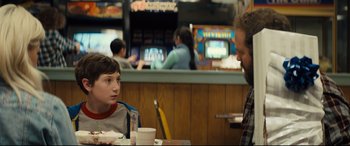 Movie still from “Brightburn” (2019), directed by David Yarovesky – A man and a boy sitting at a table in a restaurant; Medium shot, Over the shoulder angle