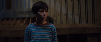Movie still from “Brightburn” (2019), directed by David Yarovesky – A young boy in a striped shirt looking to his left; Close Up shot, Over the shoulder angle