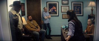 Movie still from “Brightburn” (2019), directed by David Yarovesky – A woman standing next to a man in a waiting room; Medium shot, Over the shoulder angle