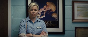 Movie still from “Brightburn” (2019), directed by David Yarovesky – A woman standing in front of a poster of a jellyfish; Close Up shot, Low angle