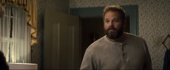 Movie still from “Brightburn” (2019), directed by David Yarovesky – A man standing in a room looking at the camera; Close Up shot, Over the shoulder angle