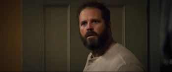 Movie still from “Brightburn” (2019), directed by David Yarovesky – A man with a goatee is looking at the camera; Close Up shot, Over the shoulder angle
