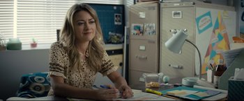 Movie still from “Brightburn” (2019), directed by David Yarovesky – A woman sitting at a desk writing on a piece of paper; Medium shot, Over the shoulder angle