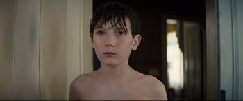 Movie still from “Brightburn” (2019), directed by David Yarovesky – A young boy with wet hair is posing for a picture; Close Up shot, High angle