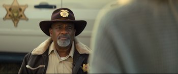 Movie still from “Brightburn” (2019), directed by David Yarovesky – A man in a sheriff's uniform is looking into a mirror; Close Up shot, Over the shoulder angle