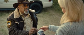 Movie still from “Brightburn” (2019), directed by David Yarovesky – An older man wearing a cowboy hat and holding a cell phone; Close Up shot, Over the shoulder angle