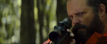Movie still from “Brightburn” (2019), directed by David Yarovesky – A man with a rifle looking through a scope; Close Up shot, Over the shoulder angle