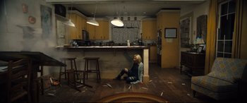 Movie still from “Brightburn” (2019), directed by David Yarovesky – A woman sitting on the floor of a kitchen; Wide shot, High angle
