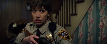 Movie still from “Brightburn” (2019), directed by David Yarovesky – A woman in a sheriff's uniform holding a microphone; Close Up shot, Over the shoulder angle