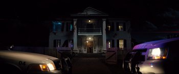 Movie still from “Brightburn” (2019), directed by David Yarovesky – A large white house with a porch lit up at night; Extreme Wide shot, Low angle