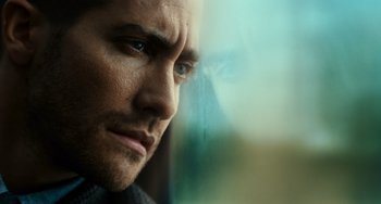 Movie still from “Source Code” (2011), directed by Duncan Jones – A man's face as seen through a window; Close Up shot, Low angle