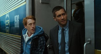 Movie still from “Source Code” (2011), directed by Duncan Jones – Two men sitting next to each other on a bus; Medium shot, Over the shoulder angle