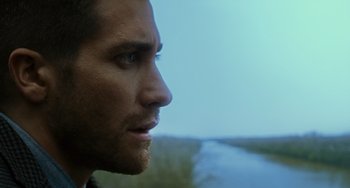 Movie still from “Source Code” (2011), directed by Duncan Jones – A man's face looking out over a river; Close Up shot, Over the shoulder angle