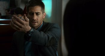 Movie still from “Source Code” (2011), directed by Duncan Jones – A person holding a gun; Close Up shot, Over the shoulder angle