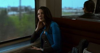 Movie still from “Source Code” (2011), directed by Duncan Jones – A woman sitting on a train looking out the window; Medium shot, Low angle