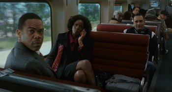 Movie still from “Source Code” (2011), directed by Duncan Jones – A woman sitting on a seat on a train while talking on a phone; Medium shot, High angle