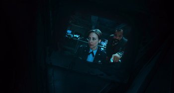 Movie still from “Source Code” (2011), directed by Duncan Jones – A man and a woman in uniform looking at something on a screen; Close Up shot, Overhead angle