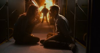 Movie still from “Source Code” (2011), directed by Duncan Jones – A man and a woman sitting on the floor in front of a fire; Wide shot, High angle