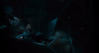 Movie still from “Source Code” (2011), directed by Duncan Jones – A man laying on the ground in a dark room; Wide shot, Low angle