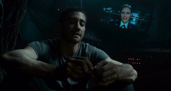 Movie still from “Source Code” (2011), directed by Duncan Jones – A man sitting in front of a woman holding a cell phone; Close Up shot, Over the shoulder angle