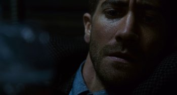 Movie still from “Source Code” (2011), directed by Duncan Jones – A man's face in the dark; Close Up shot, Over the shoulder angle