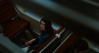 Movie still from “Source Code” (2011), directed by Duncan Jones – A woman sitting on a seat on a train; Medium shot, Overhead angle