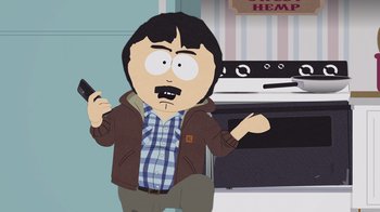 Movie still from “South Park: Joining the Panderverse” (2023), directed by Trey Parker – A man holding a cell phone while standing in front of an oven; Medium shot, Low angle