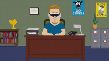 Movie still from “South Park: Joining the Panderverse” (2023), directed by Trey Parker – A man sitting at a desk in front of a computer; Medium shot, Low angle