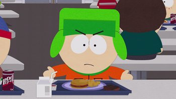 Movie still from “South Park: Joining the Panderverse” (2023), directed by Trey Parker – A person sitting at a table with a plate of food in front of him; Medium shot, High angle