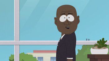 Movie still from “South Park: Joining the Panderverse” (2023), directed by Trey Parker – A bald man in a black suit is standing in front of a building; Medium shot, Over the shoulder angle